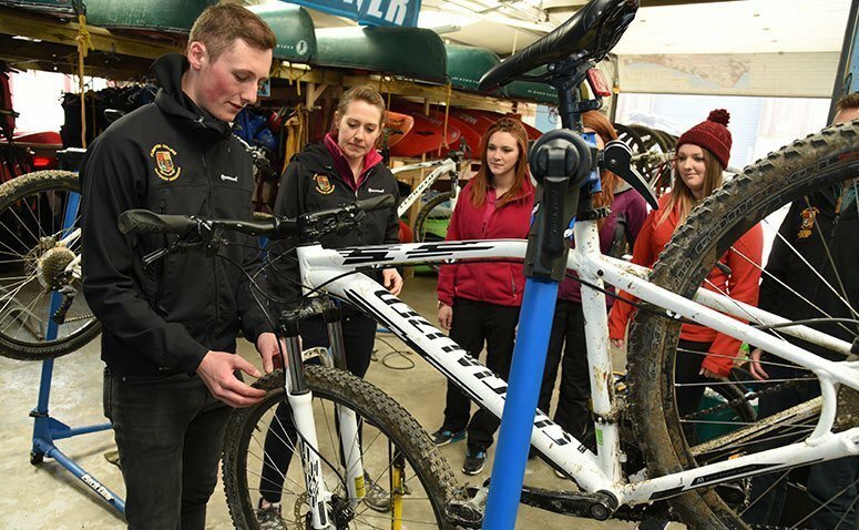 Group of students and a tutor with a mountain bike