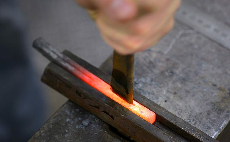 Decorative work being hammered into hot metal