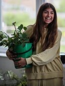 Young woman with bucket of flowers