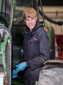 Young man with cow milking machinery