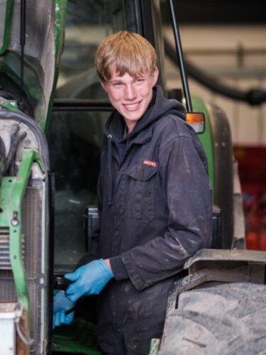 Young man with cow milking machinery
