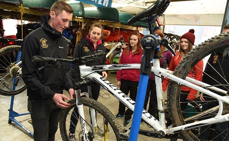 Group of students and a tutor with a mountain bike